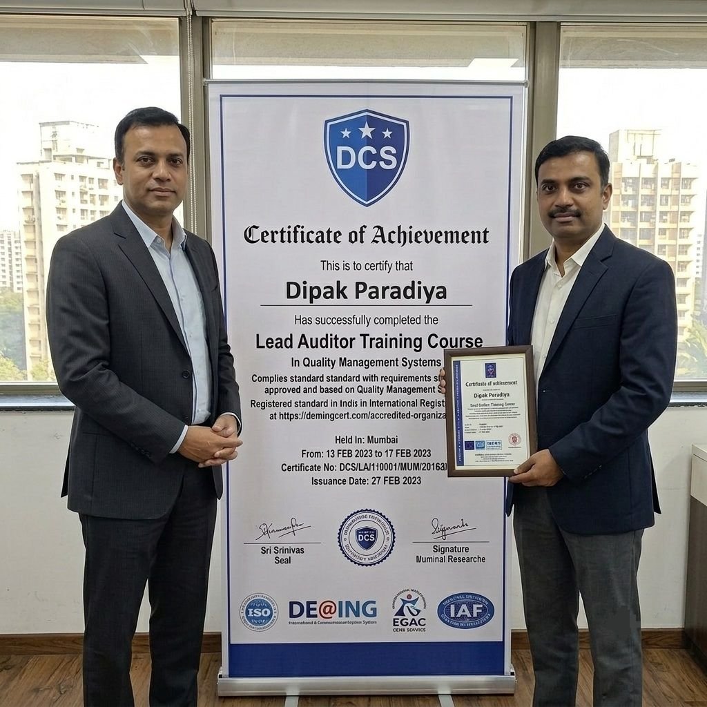 Dipak Paradiya receiving his framed ISO 9001 Quality Management Systems Lead Auditor Certificate from a representative standing beside a large Deming Certification Services banner.